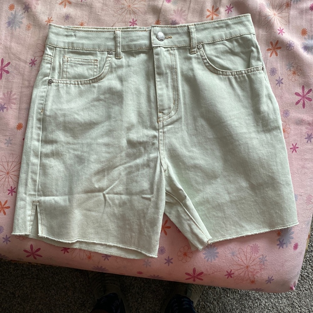 Light green mid length shorts.